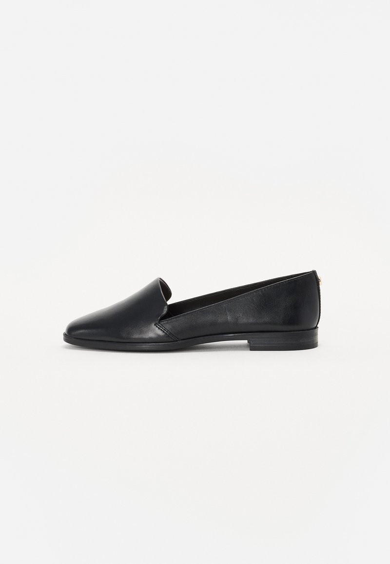 Sorte lær flatsko med spiss tå, utskårne sider og lav hæl, med en glatt tekstur og minimalistisk design.
