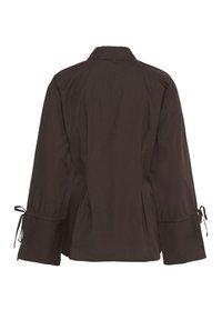 Brown long-sleeve blouse with wide cuffs and adjustable tie details on sleeves, featuring a classic collar and relaxed fit.