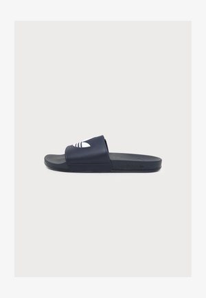 Einzelne schwarze Adidas Slide-Sandale mit weißem Logo auf dem Riemen, texturierter Innensohle und flacher Sohle auf einem schlichten hellen Hintergrund.