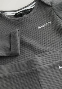 Grau strukturierter Waffelpullover mit Rundhalsausschnitt, gerippten Bündchen und dem auf der Vorderseite in Weiß gestickten "ALLSAINTS"-Logo.