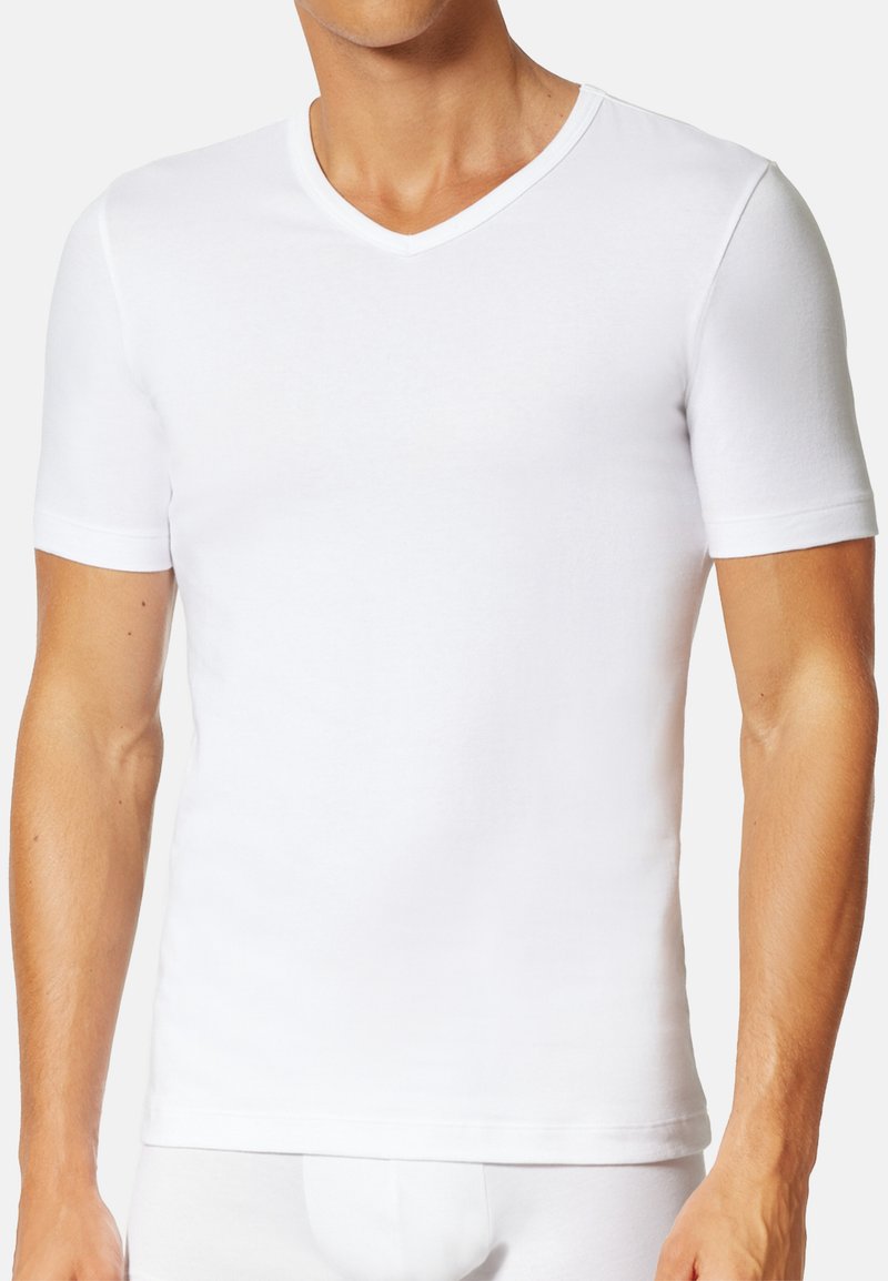 T-shirt blanc à manches courtes avec un col en V, fabriqué en coton doux, forme ajustée, coutures minimales et sans logos visibles.