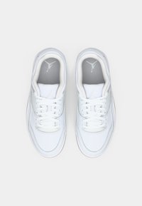 Ζευγάρι λευκών αθλητικών παπουτσιών Air Jordan με κορδόνια, θαμμένοι από πάνω σε ένα απλό ανοιχτό φόντο.