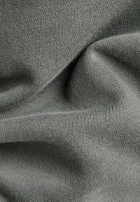 Světle šedá bavlněná látka s hladkou texturou, zdobená jemnými vlnitostmi a jemným pleteným vzorem.