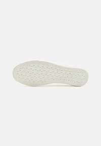 Suola di una sneaker bianca con un motivo testurizzato che presenta un disegno geometrico a rombi, bordi lisci e materiale flessibile.