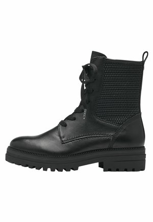 Bottines noires avec un corps en cuir lisse et un panneau latéral en mesh. Présentent un bout rond, un laçage à l'avant et une semelle robuste pour l'adhérence.