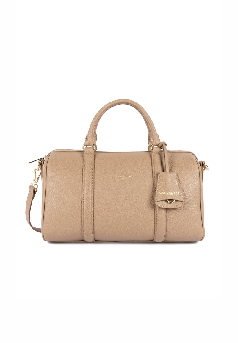 Borsa a mano in pelle beige con design strutturato, doppie maniglie superiori, tracolla rimovibile e un piccolo cartellino attaccato con dettagli dorati.