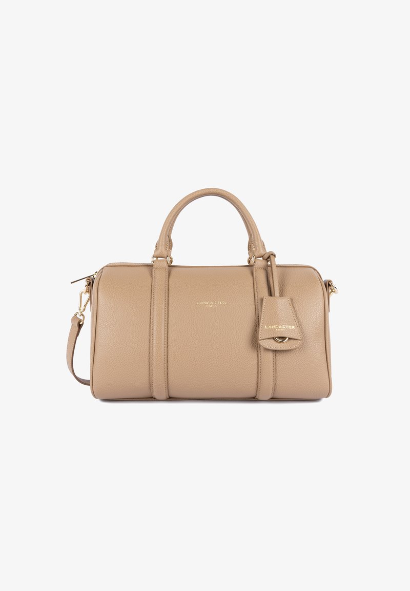 Borsa a mano in pelle beige con design strutturato, doppie maniglie superiori, tracolla rimovibile e un piccolo cartellino attaccato con dettagli dorati.