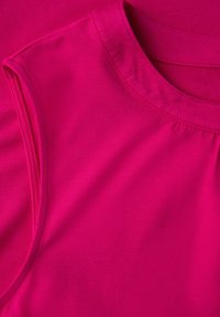 Top senza maniche fucsia realizzato in tessuto morbido, caratterizzato da un colletto rotondo e dettagli arricciati sulle spalle per un tocco di texture in più.