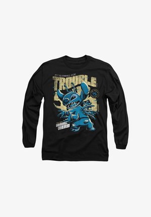 Schwarzes Langarm-T-Shirt mit einem blauen Cartoon-Charakter mit übertriebenen Merkmalen und Sprüchen auf einem abgenutzten beigen Hintergrund.