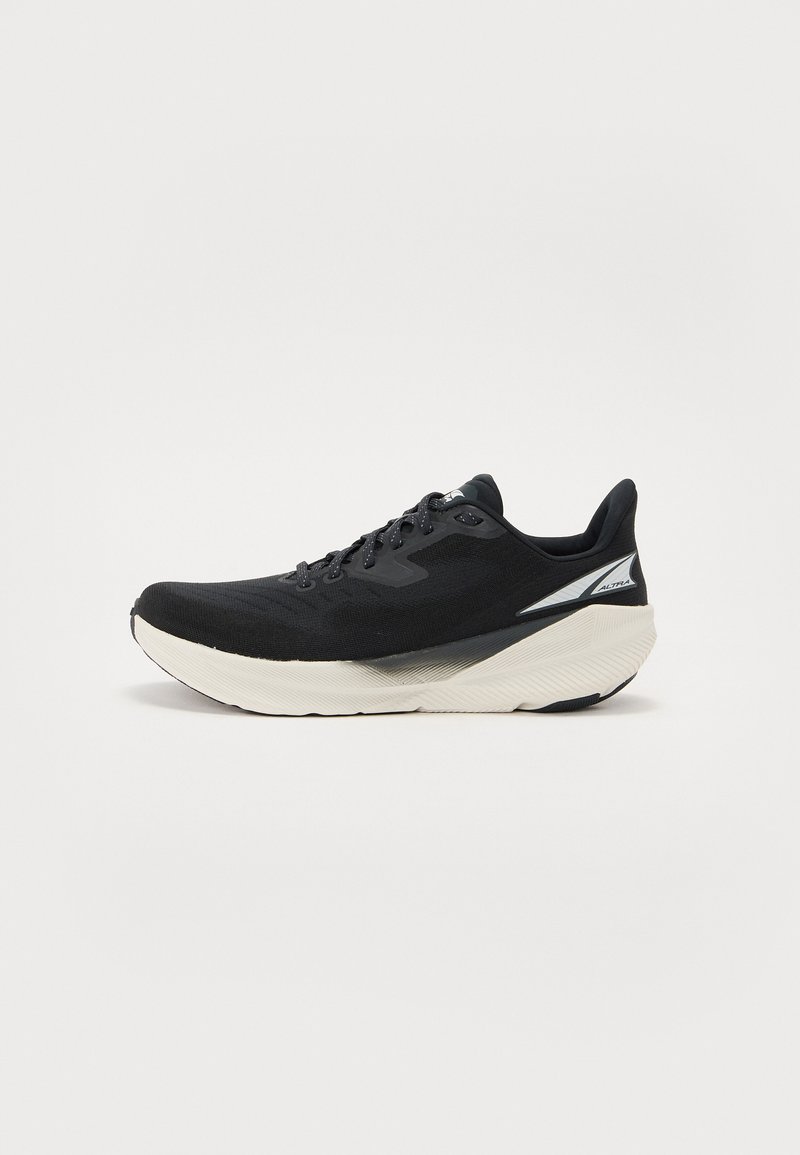 Black running shoe with a mesh upper, textured sole, and a white midsole. Features a flat lace design and reinforced heel support.
