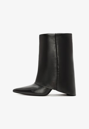 Czarne skórzane botki sięgające kostki z ostrym noskiem i unikalną, ustrukturyzowaną, wydłużoną sylwetką. Gładka textura z detalami szycia.