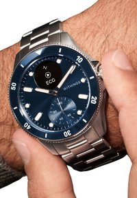 Metall-Smartwatch mit blauem Ziffernblatt, silbernen Akzenten und EKG-Anzeige. Verfügt über ein Armband aus Edelstahl und eine drehbare Lünette mit Minutenmarkierungen.