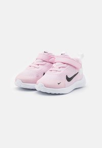 Des chaussures de sport roses fabriquées en matériau en maille avec un logo noir, une semelle blanche et une sangle en velcro. Elles présentent un bout arrondi et un design rembourré.