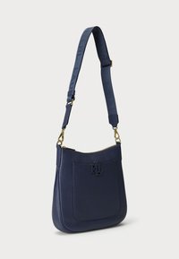 Marineblaue Lederhandtasche mit strukturiertem Oberflächen, goldenen Hardware-Elementen und geprägtem Logo. Verfügt über einen abnehmbaren Tragegurt mit Beschriftung.