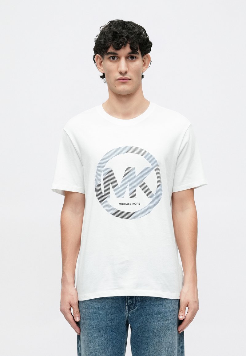 Camiseta de algodón blanca con un gráfico circular que presenta el logotipo "MK" y el texto "MICHAEL KORS" en negro y gris. Ajuste estándar con mangas cortas.