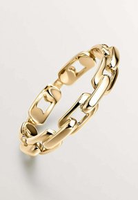 Pulsera de cadena de oro con eslabones entrelazados y un acabado brillante y suave. Los eslabones son alargados y cuentan con secciones recortadas para una textura adicional.