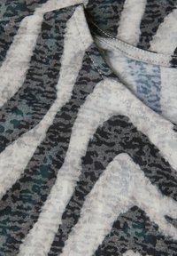 Un tessuto leggero presenta un motivo astratto in diverse tonalità di grigio, nero e teal, con una texture liscia e un colletto tondo.