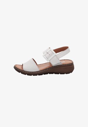 White open-toe sandal with adjustable buckle strap, woven front band, cushioned tan insole, and thick brown textured sole.