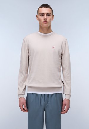 Light beige knit sweatshirt with a crew neckline and ribbed cuffs, featuring a small flag logo on the chest and a side tag detail.