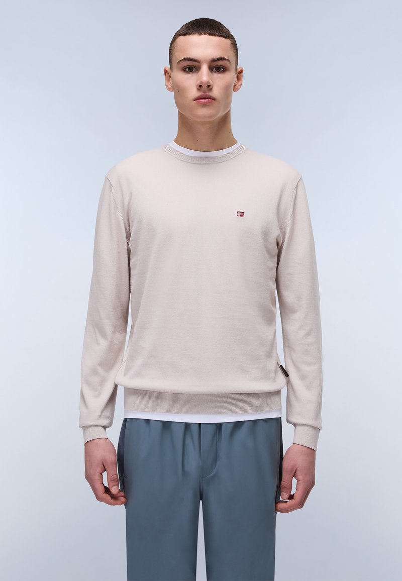 Lichtbeige gebreid sweatshirt met een ronde hals en ribgebreide manchetten, met een klein vlaglogo op de borst en een zijlabeldetail.