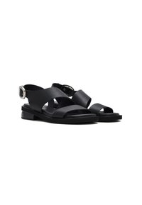 Zwarte leren sandalen met kruislings gespen, een platte zool en een verstelbare gesp. Geweven materiaal, minimalistisch ontwerp, open tenen stijl.