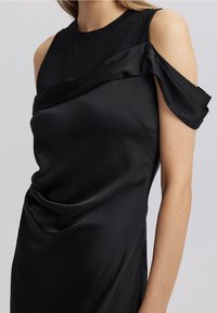 Musta satiini mekko, jossa on olkatavoitteeton muotoilu, hienostuneet laskokset ja istuva siluetti, joka on sileä ja kiiltävä.