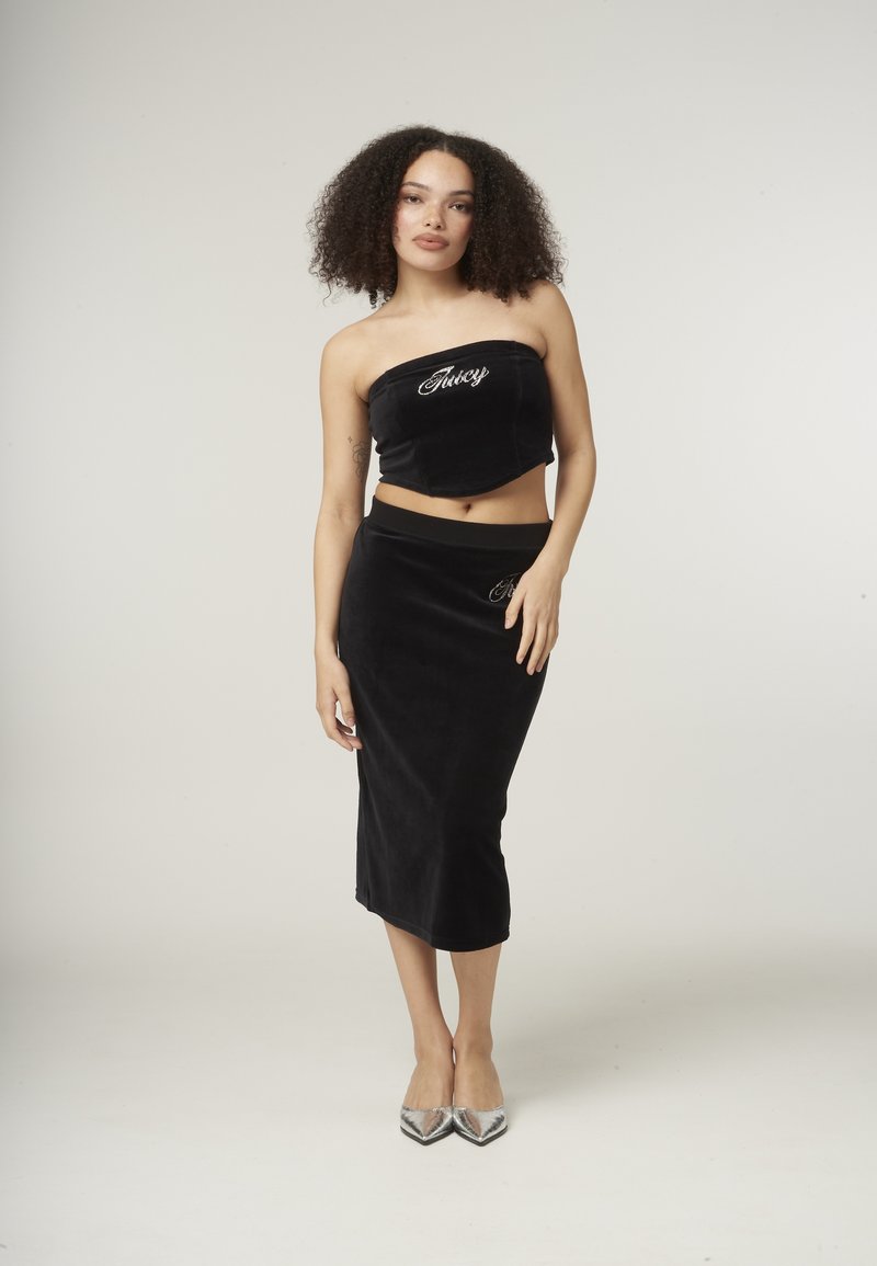 Črn žametni dvodelni komplet, ki vključuje brezramni crop top z vezenjem "Juicy" ter ujemajočo se midi krilo s prilegajočim pasom.