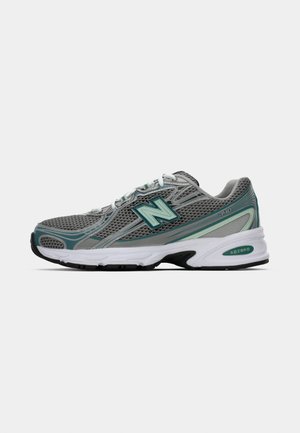 Grå och teal New Balance 740 löparsko med nätöverdel, vita snören och en vadderad vit sula med svart mönster.