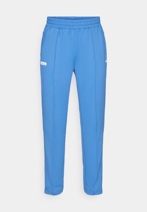 Pantalones deportivos azules con una cinturilla elástica, tela suave, dos bolsillos laterales y un pequeño logotipo blanco en el muslo izquierdo.