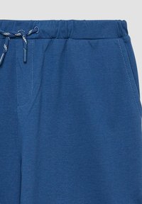 Navyblauwe sweatpants met een zachte stof, elastische tailleband met een trekkoord en zijzakken. Stikdetails zijn zichtbaar.