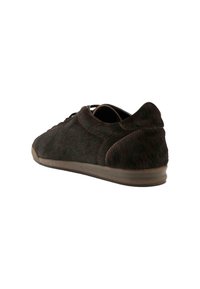 Sneaker marrone con finitura simile alla pelliccia, punta rotonda, design con lacci e suola in gomma a profilo basso. Presenta dettagli di cucitura a contrasto.