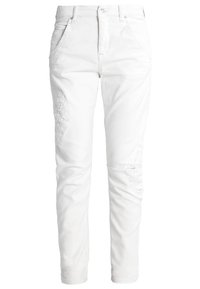 Białe dżinsy o slim fit, pięć kieszeni, haftowane detale na nogawkach oraz przetarcia powyżej kolan.