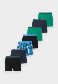 Επτά ζευγάρια ανδρικά εσώρουχα Björn Borg σε πράσινο, ναυτικό, μαύρο και μπλε με κυματιστό μοτίβο, τοποθετημένα σε διαγώνια σειρά πάνω σε λευκό φόντο.