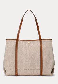 Beige geweven draagtas met bruine leren handvatten en afwerking, voorzien van een klein gouden embleem bij het bovenste midden.