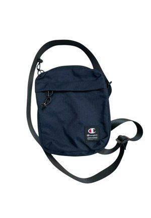 Pequeño bolso bandolera negro con correa ajustable y parche con el logo de Champion en el frente, con cremallera y detalle de tirador de cuerda.