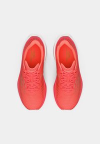 Heldere koraal hardloopschoenen met een gestructureerde mesh bovenkant, vetersluiting, gevoerde binnenkant en een witte rubberen buitenzool met subtiele branding.