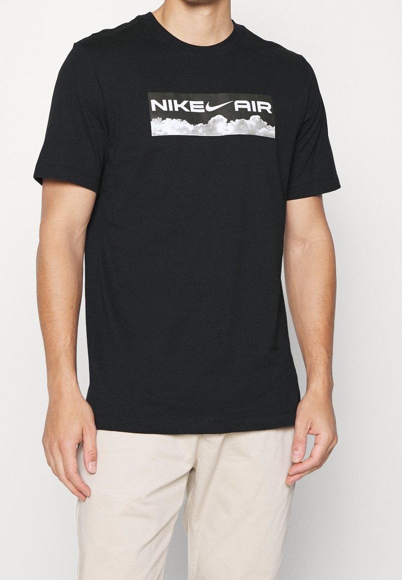 Black cotton t-shirt featuring a rectangular white Nike Air logo with a cloud graphic. Short sleeves and a crew neckline.