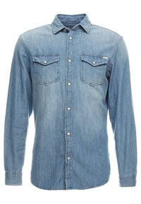 Camisa de mezclilla azul de manga larga con cuello abotonado, dos bolsillos en el pecho y botones plateados. Textura suave y diseño clásico.