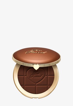 Runder Bronze-Kompaktpuder mit goldenem Rand und Herzverschluss, enthält bronzefarbene Sonnenpuder mit Schokoladentafel-Muster, geprägt mit "Too Faced" in einem Herz.