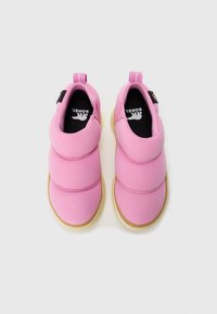 Un par de zapatos slip-on rosa con parte superior acolchada y suelas de goma marrón, vistos desde arriba sobre un fondo blanco.