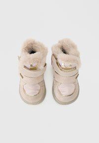 Botas de tobillo de ante rosa con forro de piel sintética, correas dobles de Velcro, punta redondeada y suela de goma texturizada. Accentos dorados en las correas.