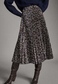 Plissé midi-jurk met een donker dierenprint in beige en marineblauw. Gemaakt van lichtgewicht stof, met een tailleband en een vloeiende silhouet.