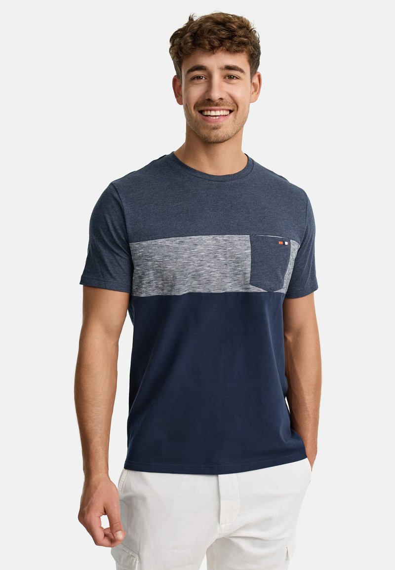 Camiseta de manga corta en azul marino con un panel de pecho a rayas grises y un bolsillo frontal. Hecha de una tela suave y lisa con un cuello redondo.