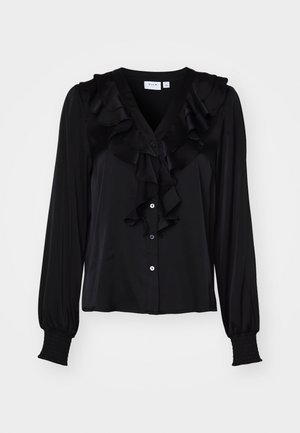 Zwarte blouse met lange mouwen, met rimpeldetails langs de halslijn, knoopsluiting en gathered manchetten. Gladde stoftextuur.