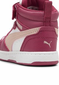 Baskets montantes en cuir rose et blanc avec une finition texturée, dotées d'une bande beigne, d'une sangle Velcro et d'une semelle en caoutchouc blanc.