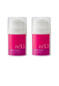 Due contenitori cilindrici bianchi con coperchi trasparenti. Le etichette in grassetto rosa riportano la scritta "Crema Mani" e i dettagli del prodotto, 50 ml ciascuno.