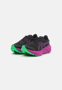 Zapatillas deportivas negras con acentos morados y una suela moteada en verde. Presentan un upper texturizado y una media suela acolchada. Los cordones son de color morado oscuro.