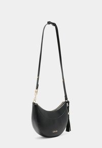 Borsa a spalla in pelle nera con forma semisferica, hardware dorato, tracolla regolabile e un accento a frangia vicino alla cerniera.