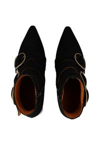 Stivali alla caviglia in suede nero con punta affusolata, accentuati da due fibbie dorate e una fodera interna arancione. Chiusura con zip laterale.