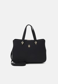 Borsa tote in pelle nera con doppio manico superiore, hardware in tonalità oro e logo impresso. Presenta una forma strutturata e una tracolla removibile.